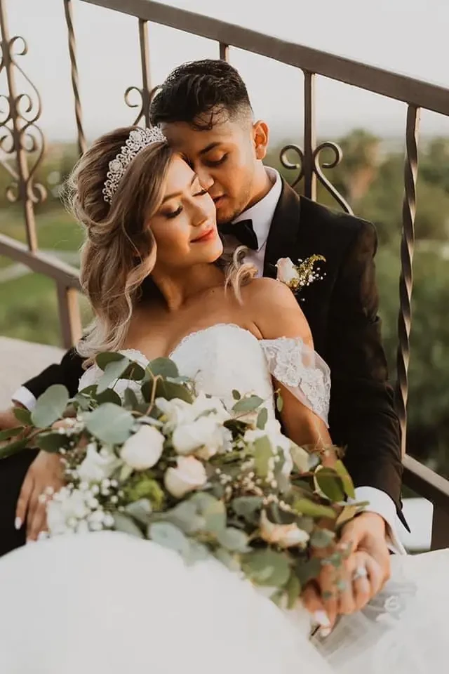 Сouple wearing a white gown and a black suit on the stairs